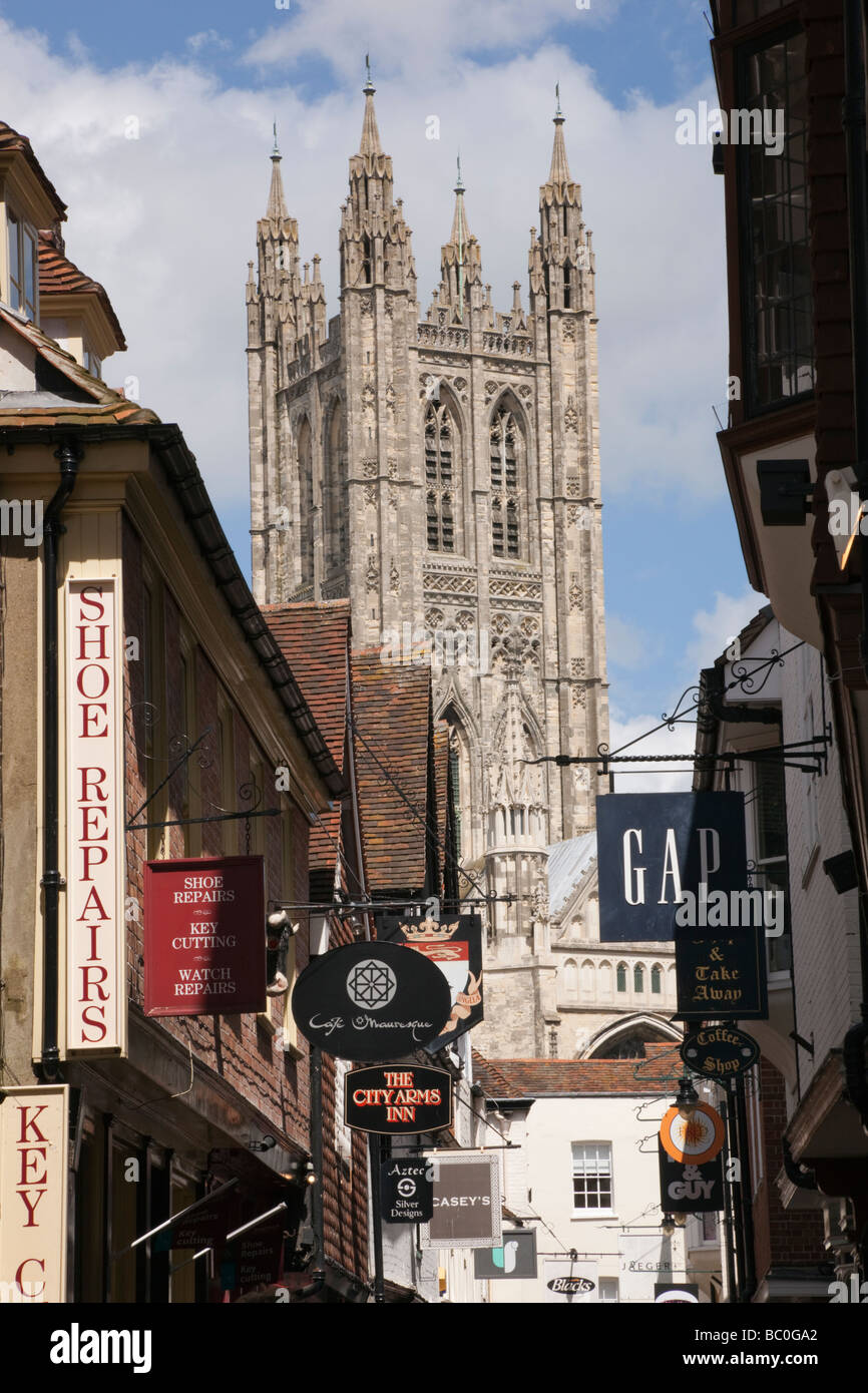 Vista della cattedrale di Canterbury chiesa torre lungo la stretta strada di negozi nel centro della citta'. Canterbury Kent England Regno Unito Gran Bretagna Foto Stock