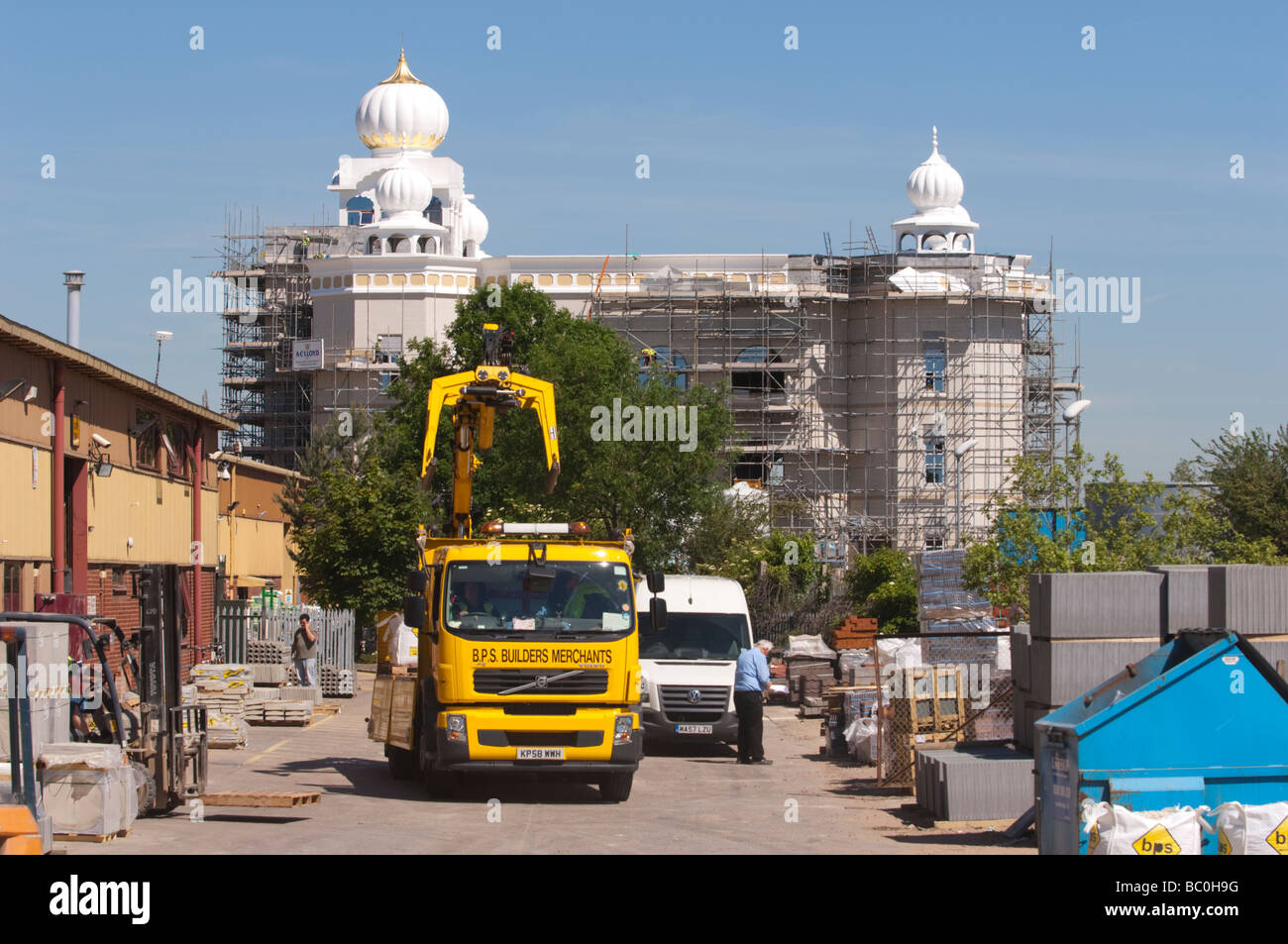 Costruttori di mercanti con Gurdwara tempio sikh sito in costruzione dietro, Leamington Spa Warwickshire, Regno Unito. Foto Stock