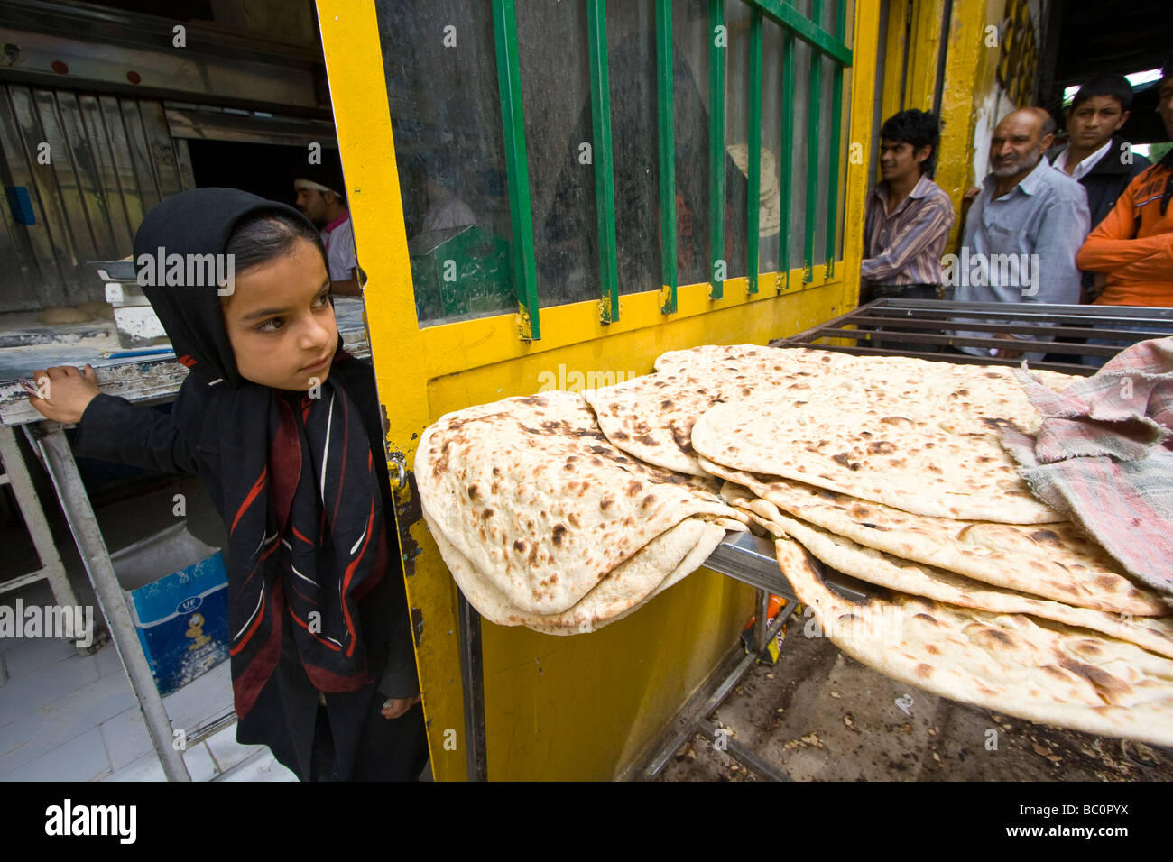 Ragazza giovane presso un negozio di pane in Kerman Iran Foto Stock