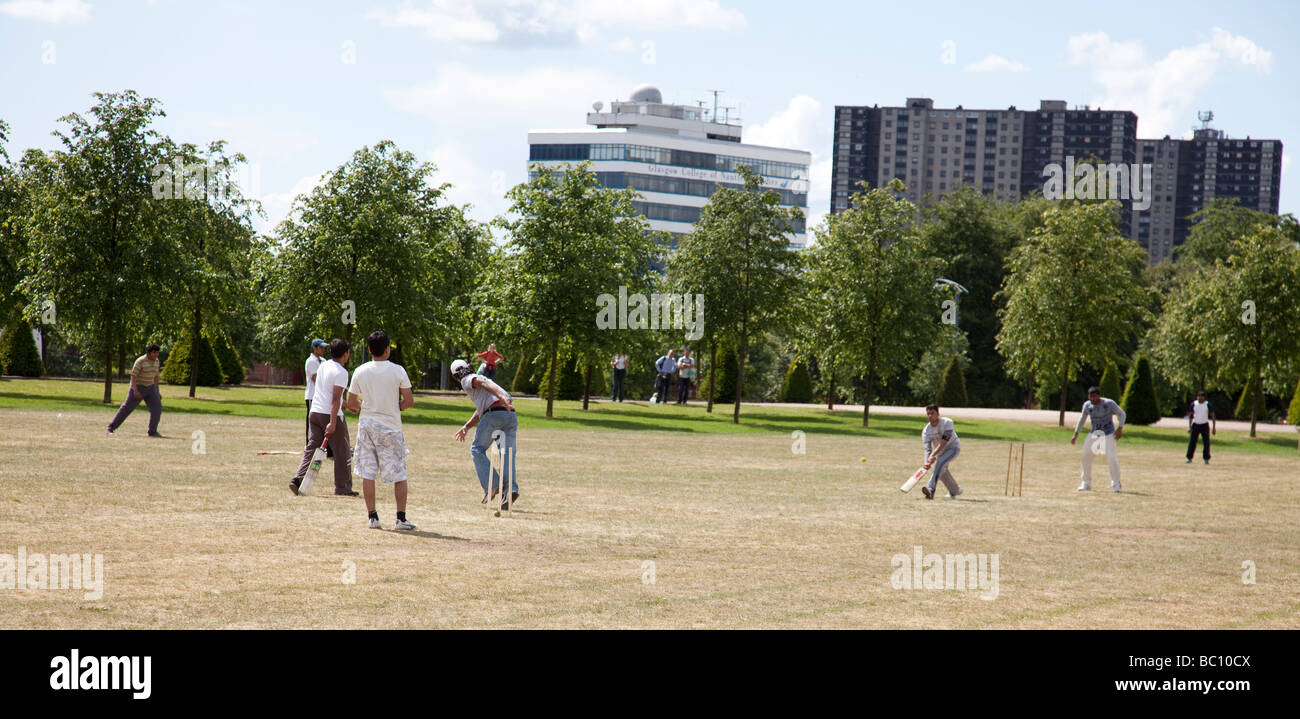 Giovani uomini asiatici a giocare a cricket su Glasgow Green Foto Stock
