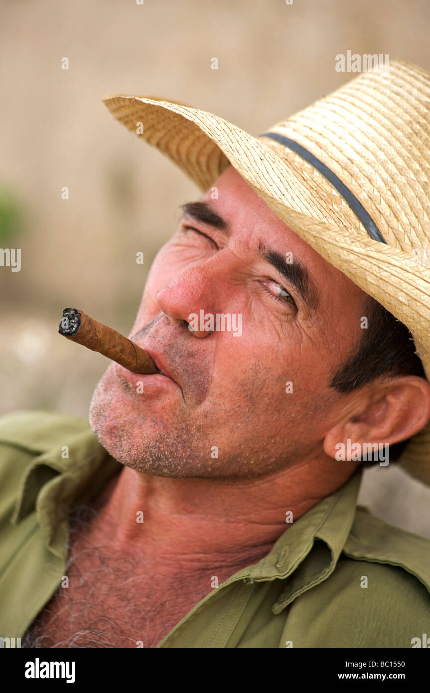 Gentile uomo cubano nel cappello distintivo e di fumare un sigaro cubano con una strizzatina d'occhio. Viñales Pinar del Rio, Cuba. Foto Stock