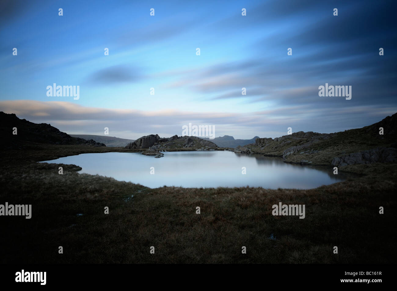 Una lunga esposizione di un lakeland tarn sul Seathwaite fells al di sopra di Borrowdale nel Lake District inglese, Cumbria, Inghilterra Foto Stock