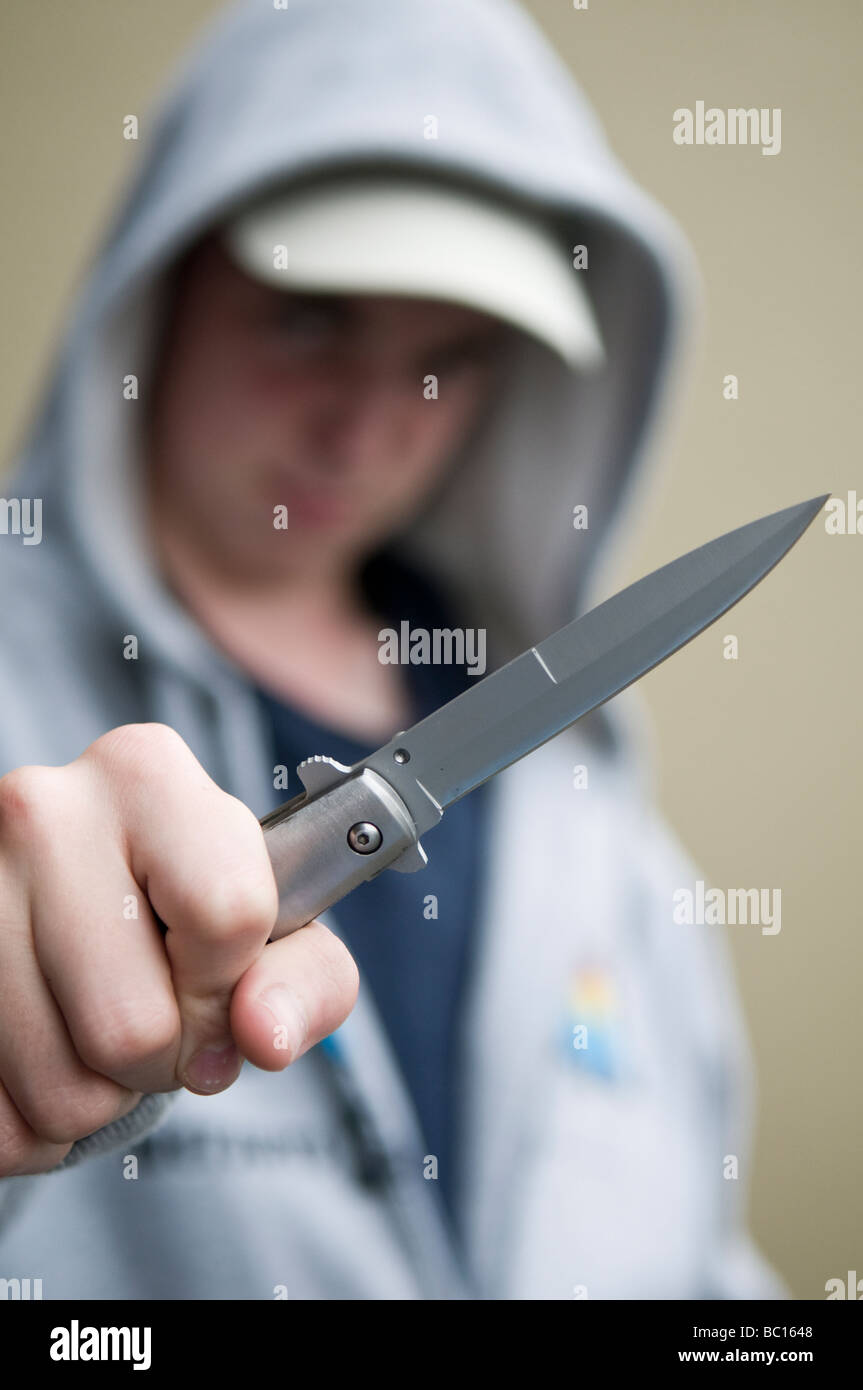 La gioventù in felpa con cappuccio brandendo sfiora il coltello Foto Stock
