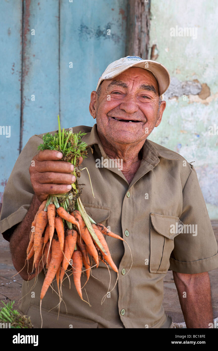 Anziani uomo cubano vendendo le carote in strada. Viñales Cuba Foto Stock