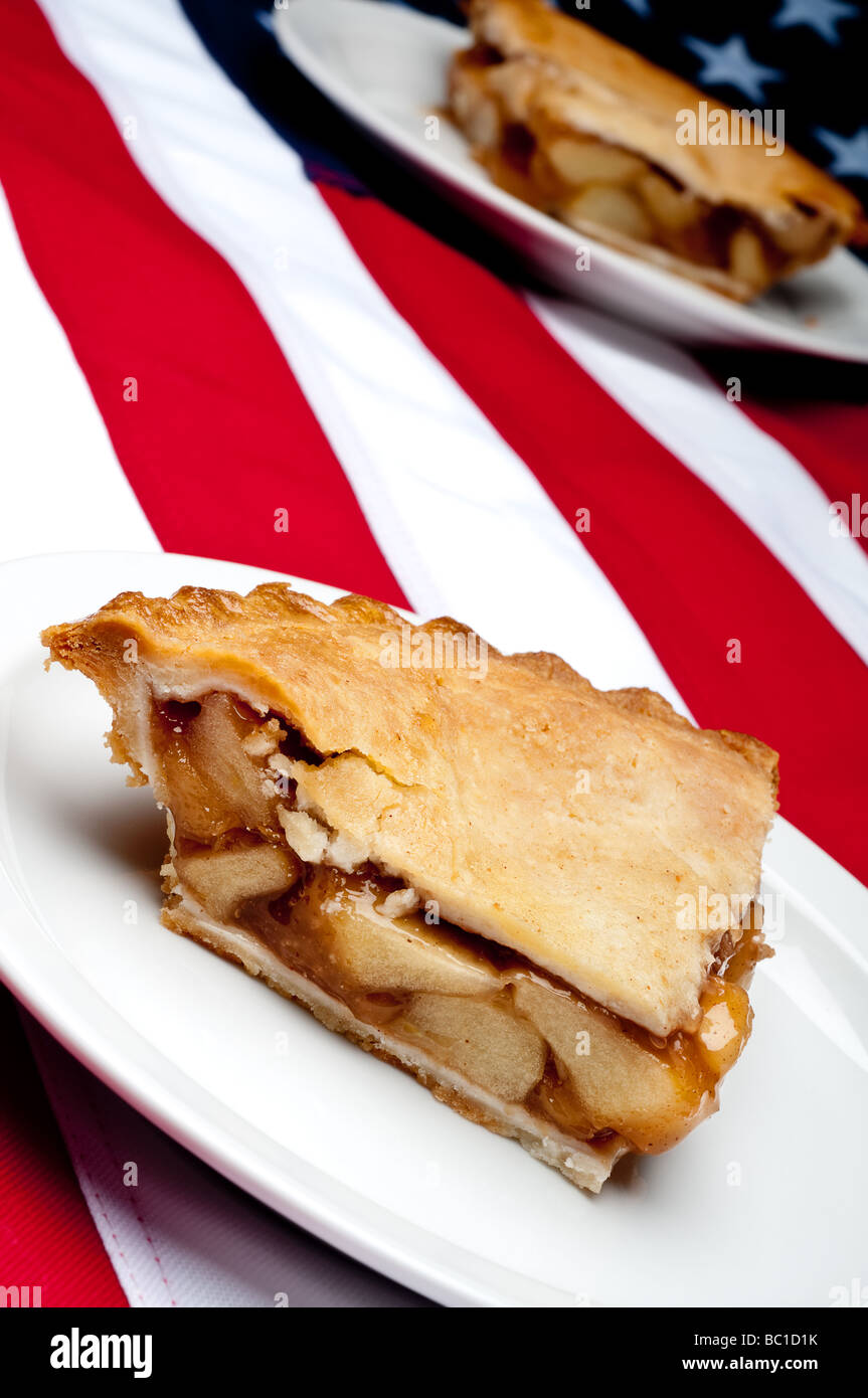 Messa a fuoco poco profonda inclinato immagine verticale di 2 pezzi di torta di mele sulla bandiera americana Foto Stock