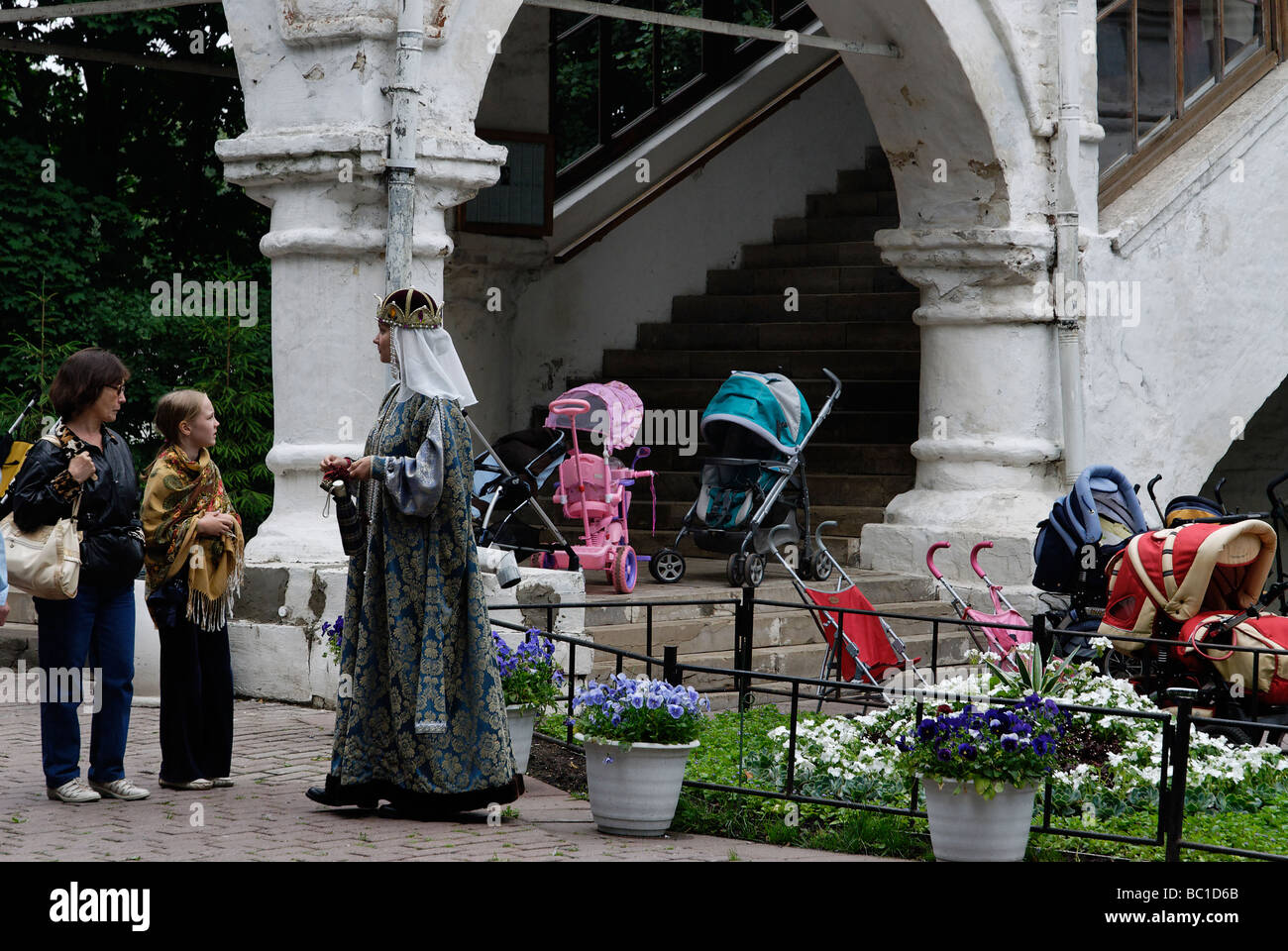 Giovane donna come guida nel tradizionale abito russo accanto la vecchia chiesa Russa di Kolomenskoe Mosca Russia Foto Stock