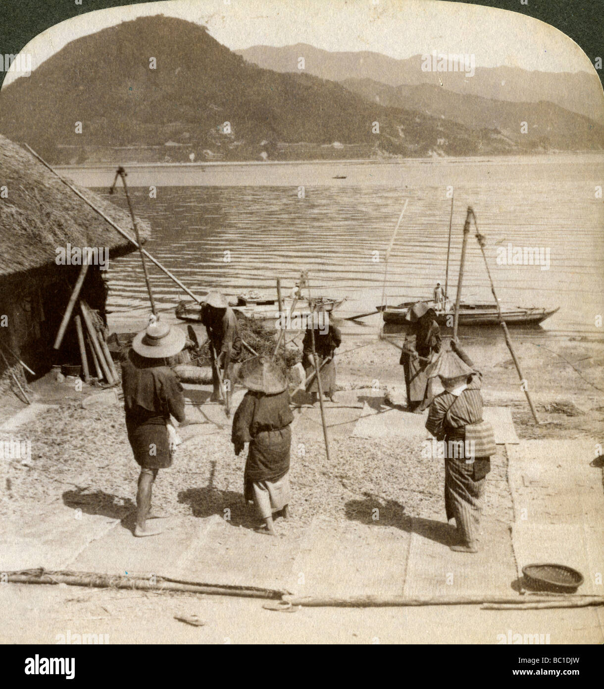 Orzo Flailing accanto ad una spiaggia di pesca sul mare interno, Giappone, 1904.Artista: Underwood & Underwood Foto Stock