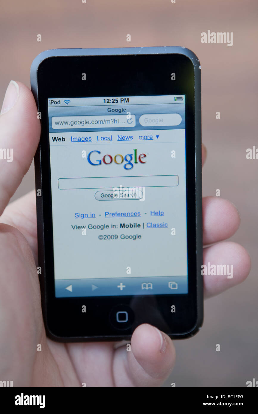 Un uomo utilizza l'applicazione browser su un Ipod Touch di Apple Foto Stock