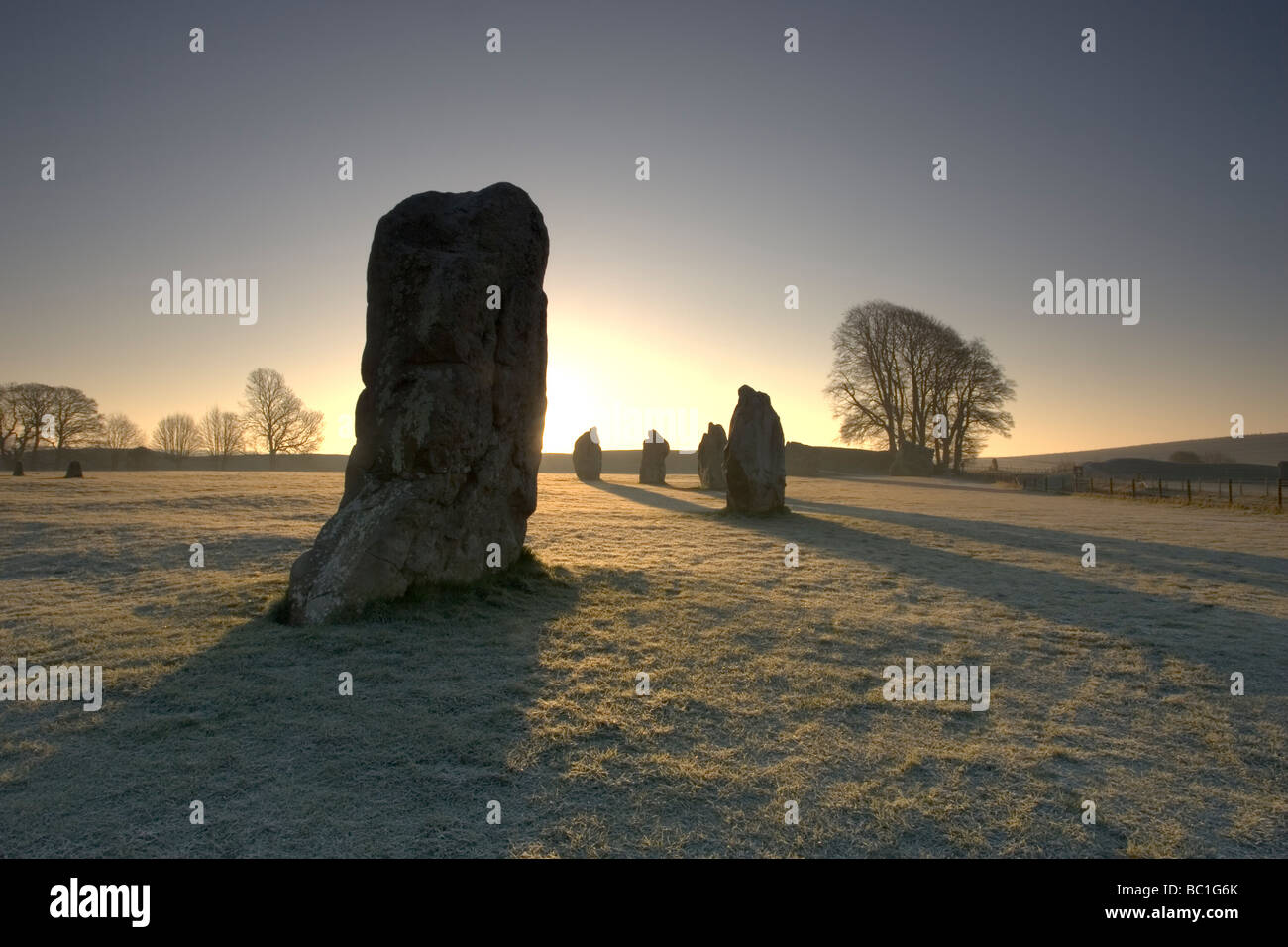 Sunrise oltre le pietre permanente presso la preistorica cerchio di Pietre di Avebury nel Wiltshire Foto Stock