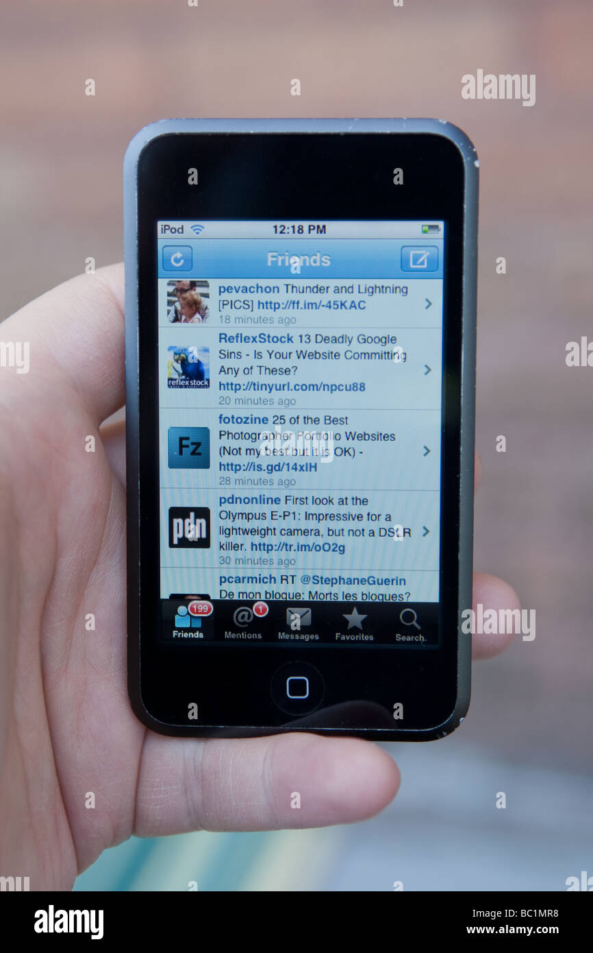Un uomo utilizza l'applicazione Facebook su un Ipod Touch di Apple. Foto Stock