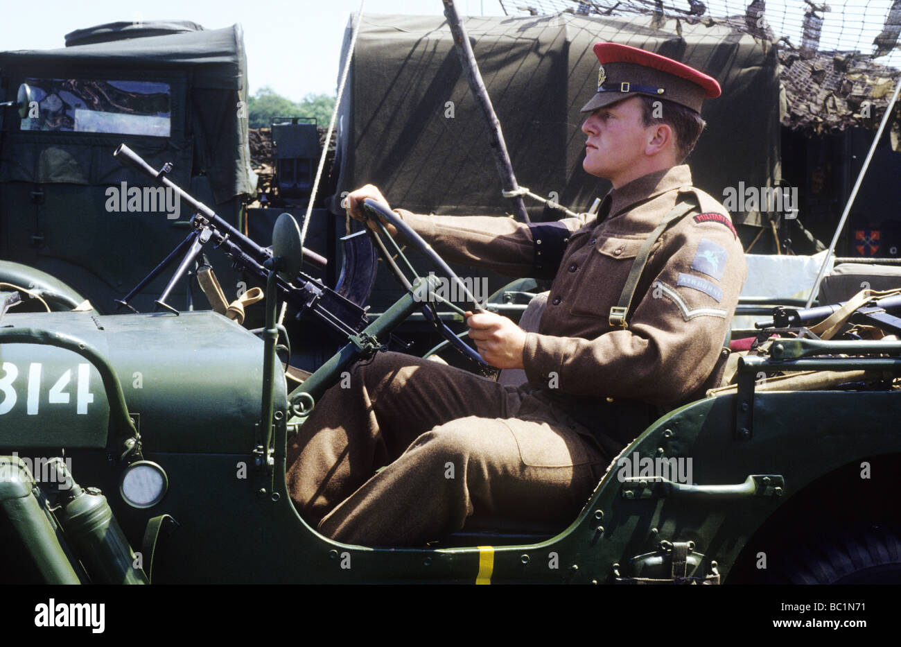 La seconda guerra mondiale la rievocazione storica MP Polizia Militare la guida jeep soldato redcap uniforme esercito britannico uniforme cachi 1940s Foto Stock