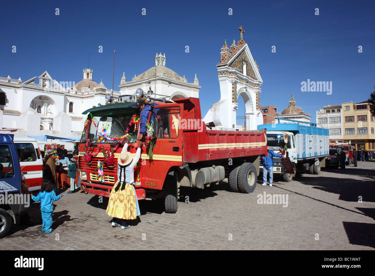 Coppia di Aymara che decorano il loro camion fuori della cattedrale prima di una cerimonia di benedizione, Copacabana, Bolivia Foto Stock