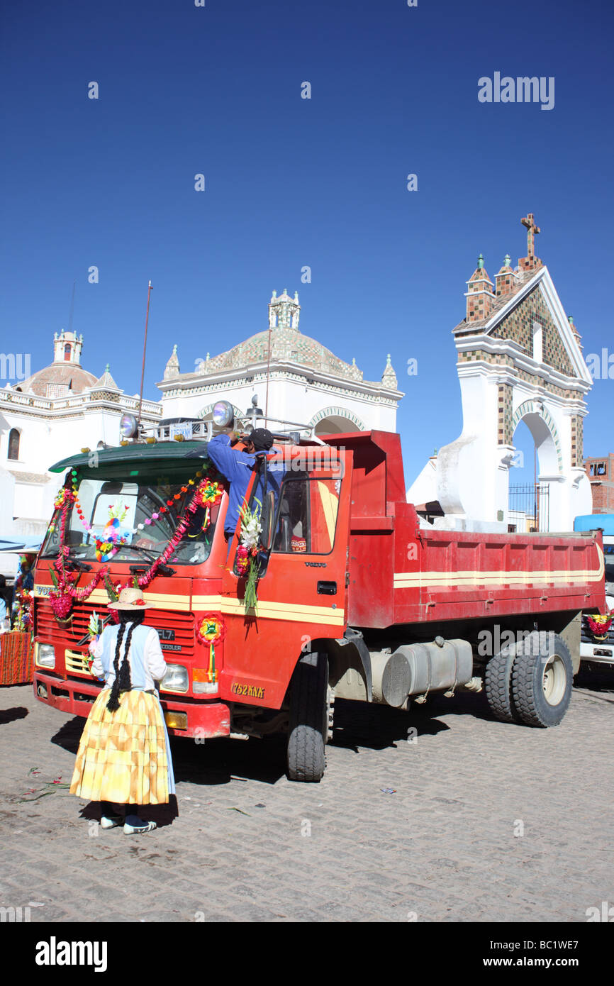 Coppia di Aymara che decorano il loro camion fuori della cattedrale prima di una cerimonia di benedizione, Copacabana, Bolivia Foto Stock