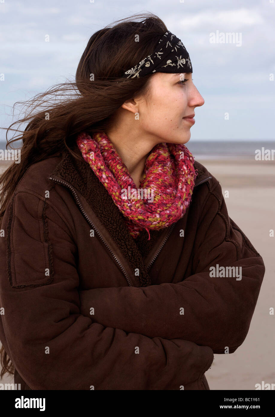 Giovane donna in piedi sulla spiaggia Foto Stock