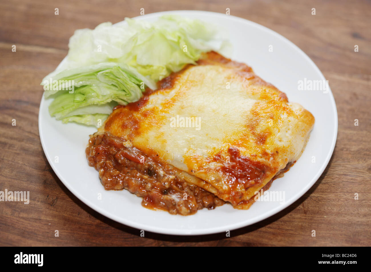 Freschi e saporiti Stile Italiano Gustosa carne bovina macinata lasagne pasto di pasta conditi con formaggio fuso con nessun popolo e insalata Grnish servita su una piastra Foto Stock