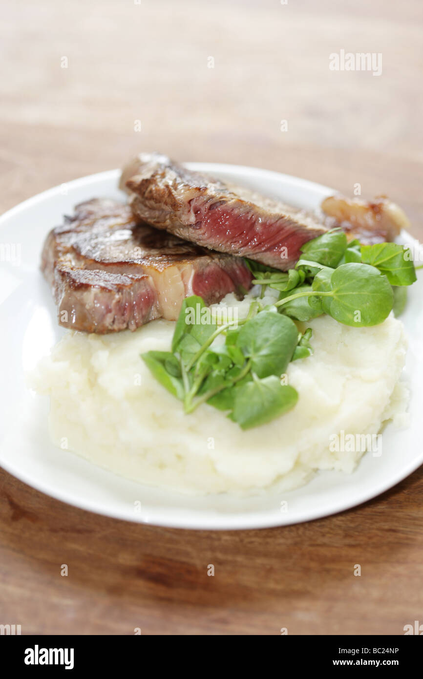 Cucinato al momento raro lombata di carne di manzo con purea di patate e crescione servita su una piastra con n. di persone Foto Stock