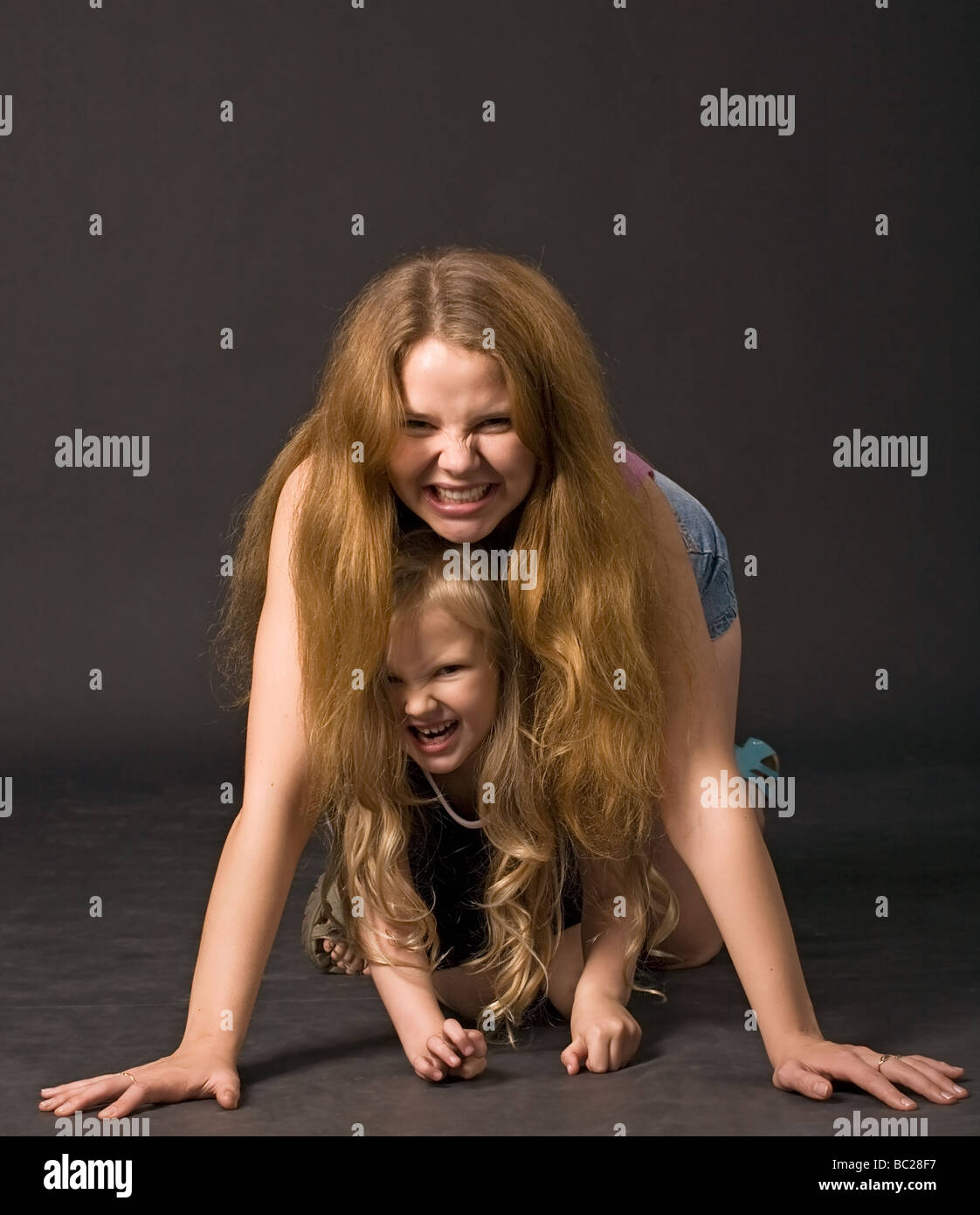 Giovane bella capelli lunghi madre e figlia con predatori di Grin Foto Stock