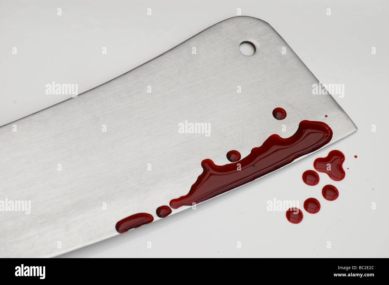Stark immagine di un taglierino per carne è spruzzato sulle con sangue finto Foto Stock