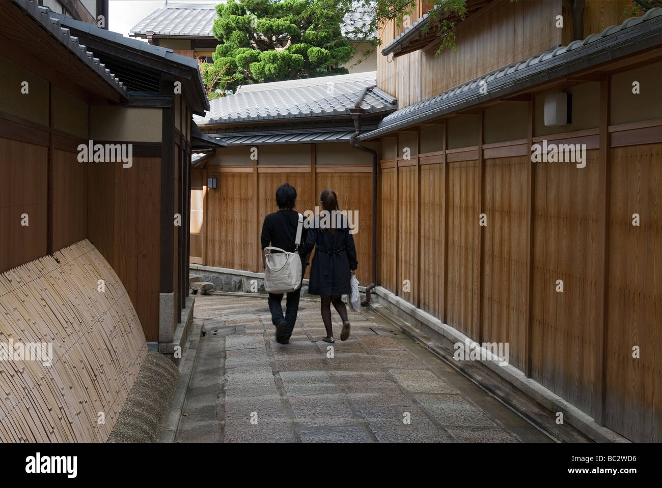 Un paio di passeggiare lungo la storica stretta viuzza conosciuta come Ishibei Koji in Higashiyama Colli orientali del distretto di Kyoto Foto Stock