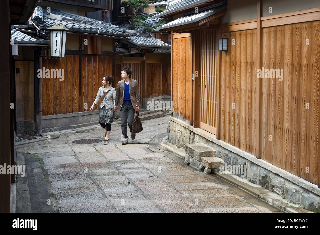 Un paio di passeggiare lungo la storica stretta viuzza conosciuta come Ishibei Koji in Higashiyama Colli orientali del distretto di Kyoto Foto Stock