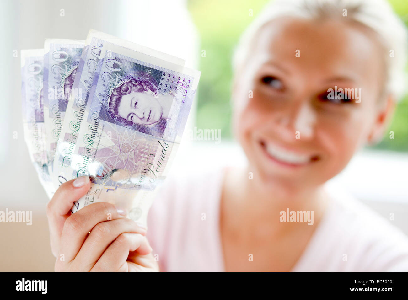 Donna che mantiene 20 pound note Foto Stock