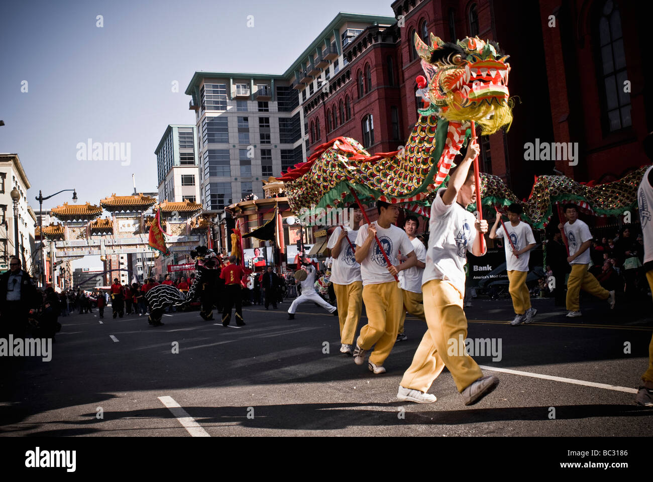 Il serpente colorato dragon sollevate da un gruppo di adolescenti danze attraverso il percorso della parata. Foto Stock