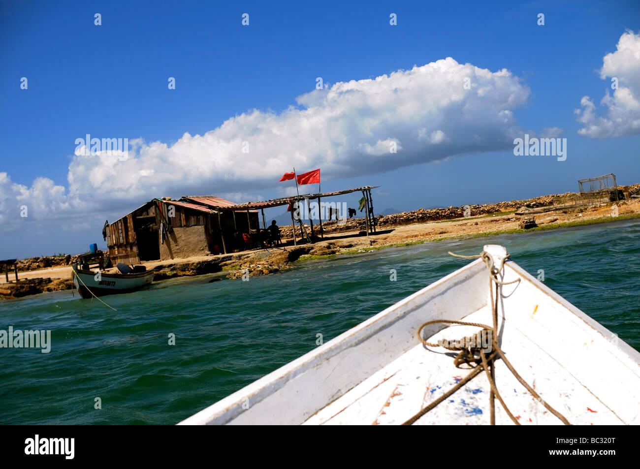 Barca da pesca si avvicina shack su isola di Cubagua, Venezuela. Foto Stock