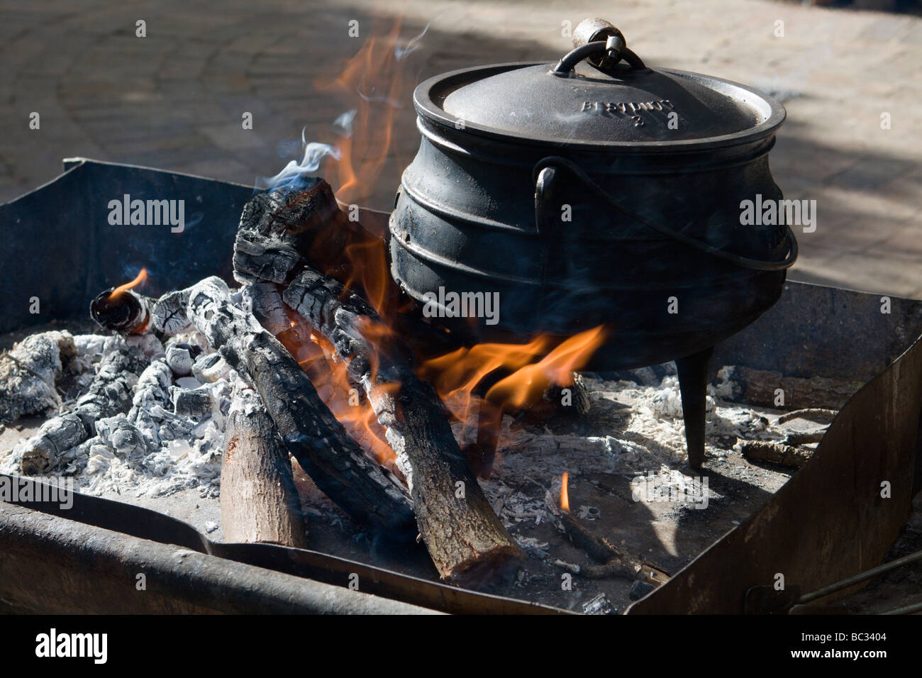 Per la cottura sul fuoco aperto con una ghisa pentola. Una ghisa pentola è utilizzato per la cottura tradizionale su un fuoco aperto in Sud Africa. Foto Stock