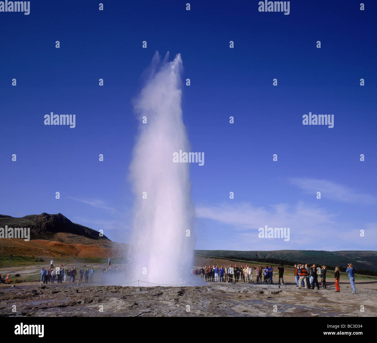 I turisti a guardare Strokkur Geyser eruttano, Sud dell'Islanda Foto Stock