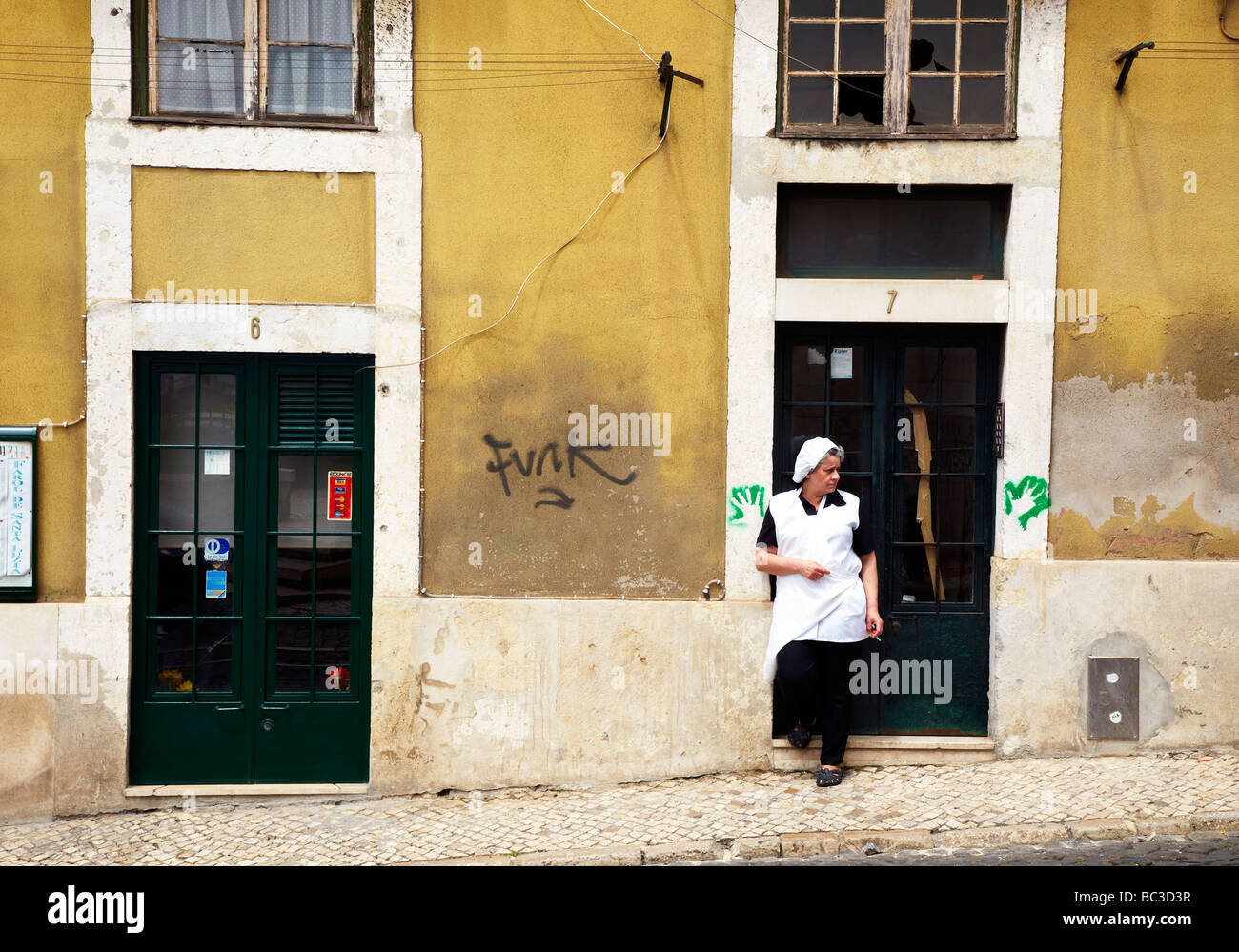 Donna dal vecchio edificio, città vecchia Lisbona, Portogallo Foto Stock