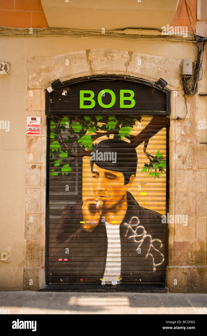 Un'opera d'arte di graffiti raffigurante al Pacino decora le persiane di un negozio di abbigliamento indipendente chiamato "BOB" a El Raval, Barcellona, Spagna. Foto Stock