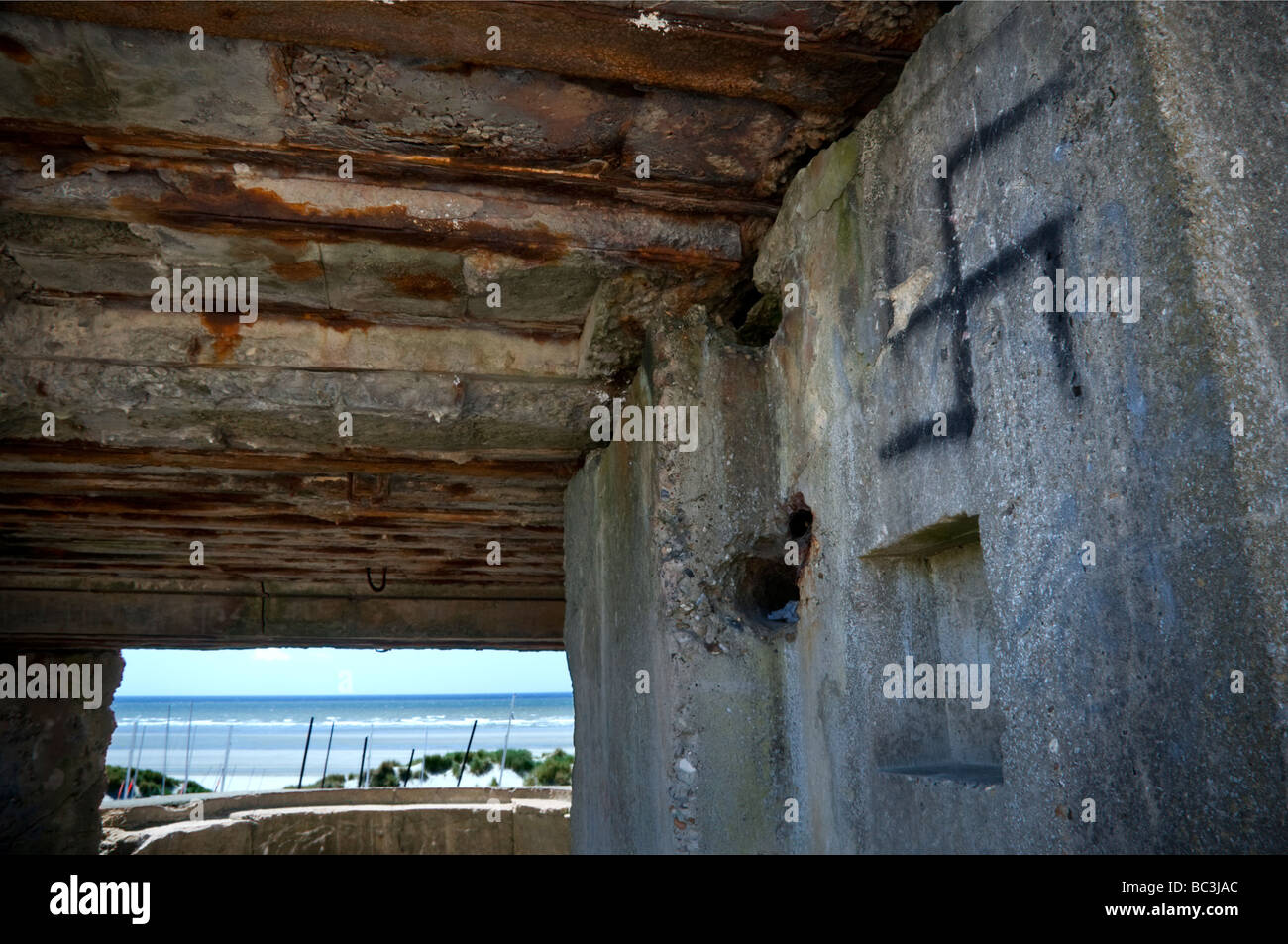 Storica WW2 calcestruzzo pistola tedesca e lookout bunker con swastika graffiti che si affaccia sulle spiagge di Fort-Mahon Plage Francia Foto Stock