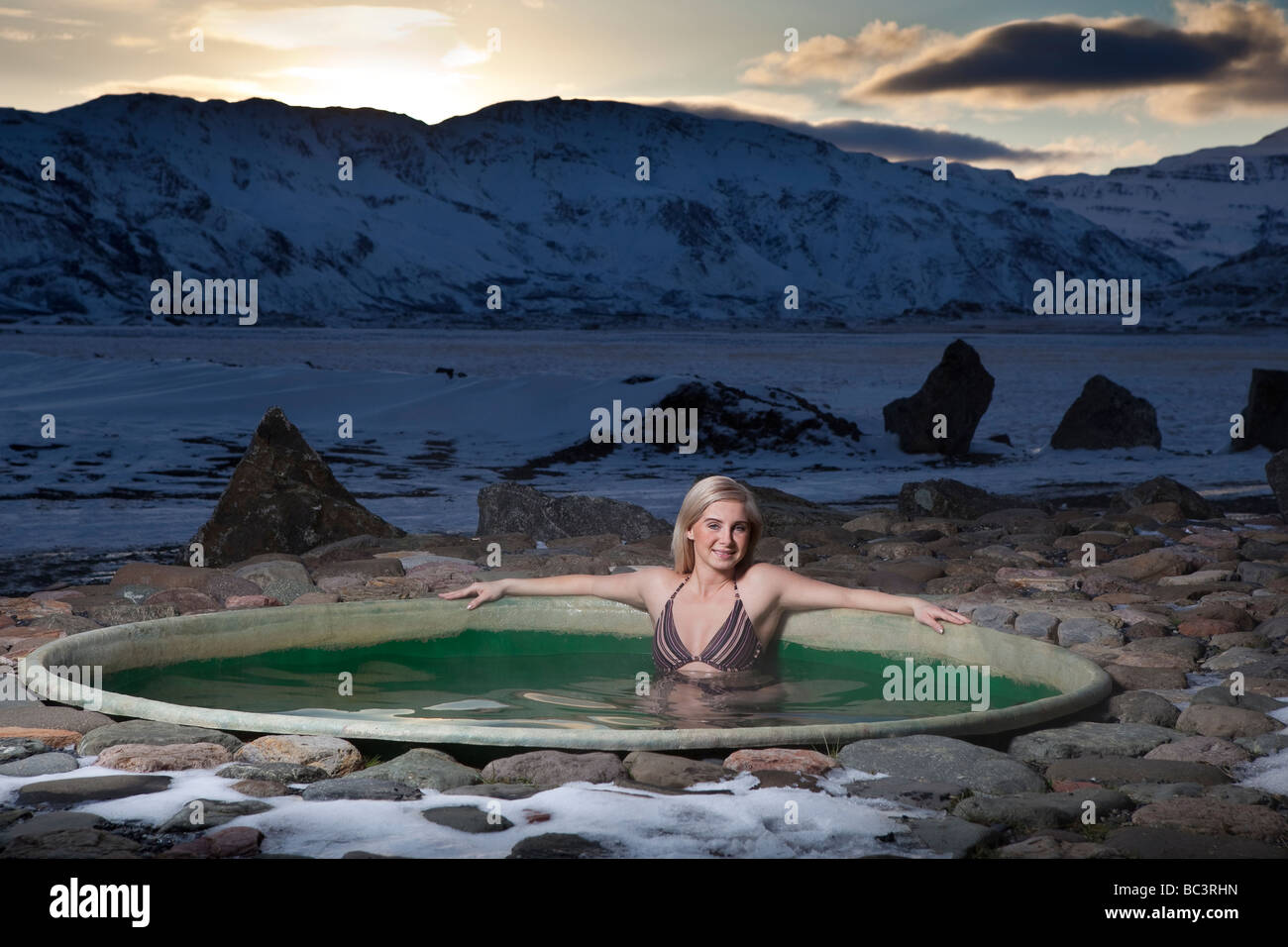 Giovane donna in energia geotermica riscaldata vasca calda, Hornafjordur, Islanda Orientale Foto Stock