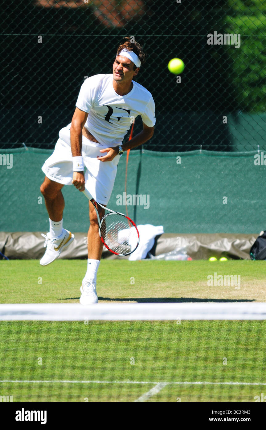La Svizzera Roger Federer gioca con Sam Querry su una pratica in tribunale durante il 2009 campionati di Wimbledon Foto Stock