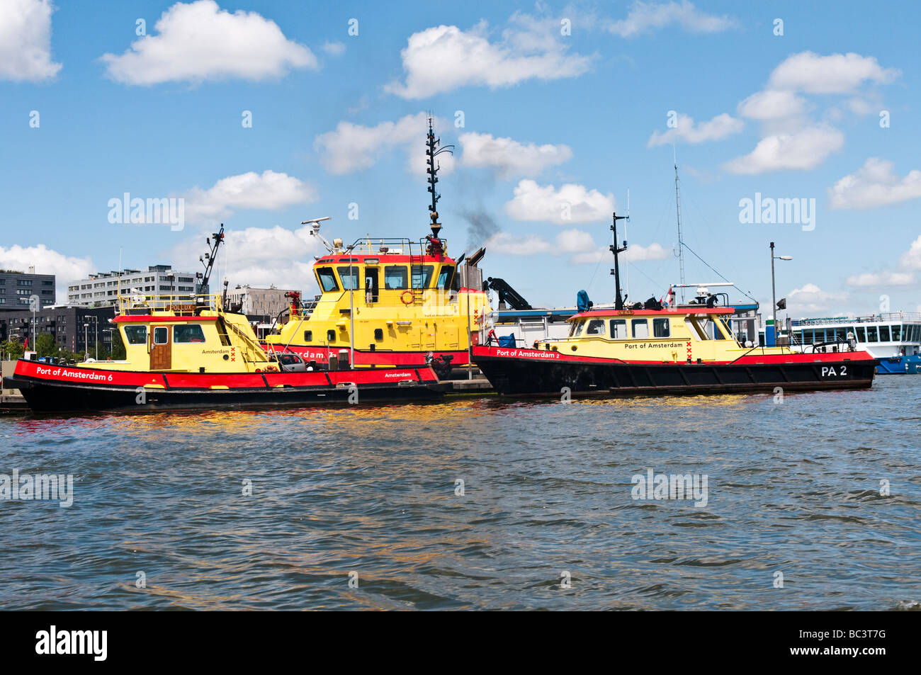 Giallo e rosso barche appartenenti al porto di Amsterdam sul Het IJ Foto Stock