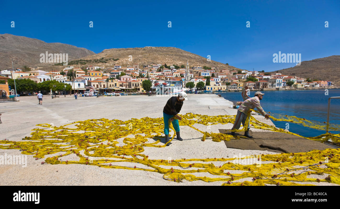 I pescatori asciugatura del colore giallo brillante reti da pesca nel porto di Chalki Rodi Grecia Foto Stock
