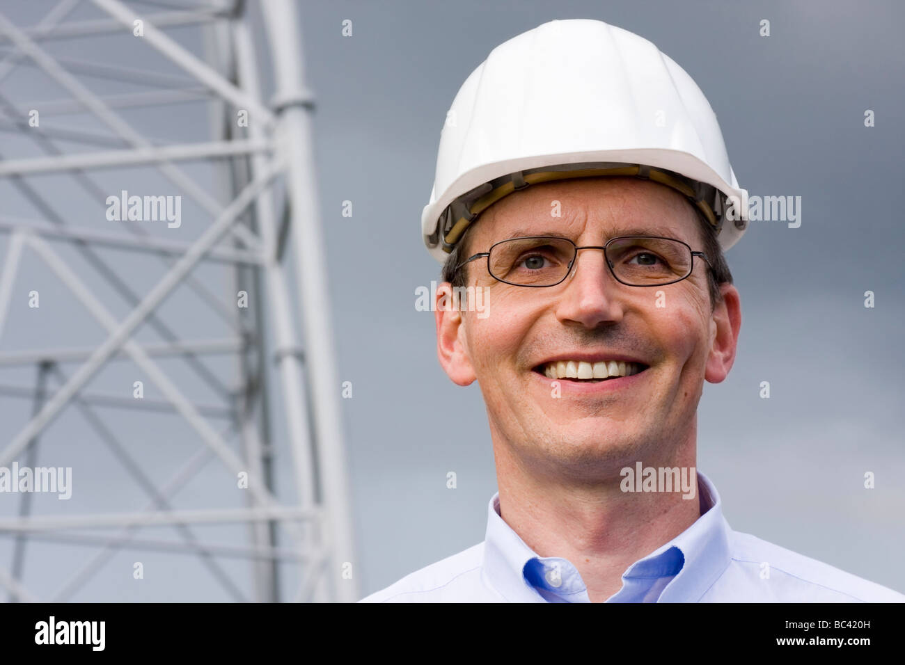 Ingegnere sorridente con hardhat sul sito in costruzione Foto Stock