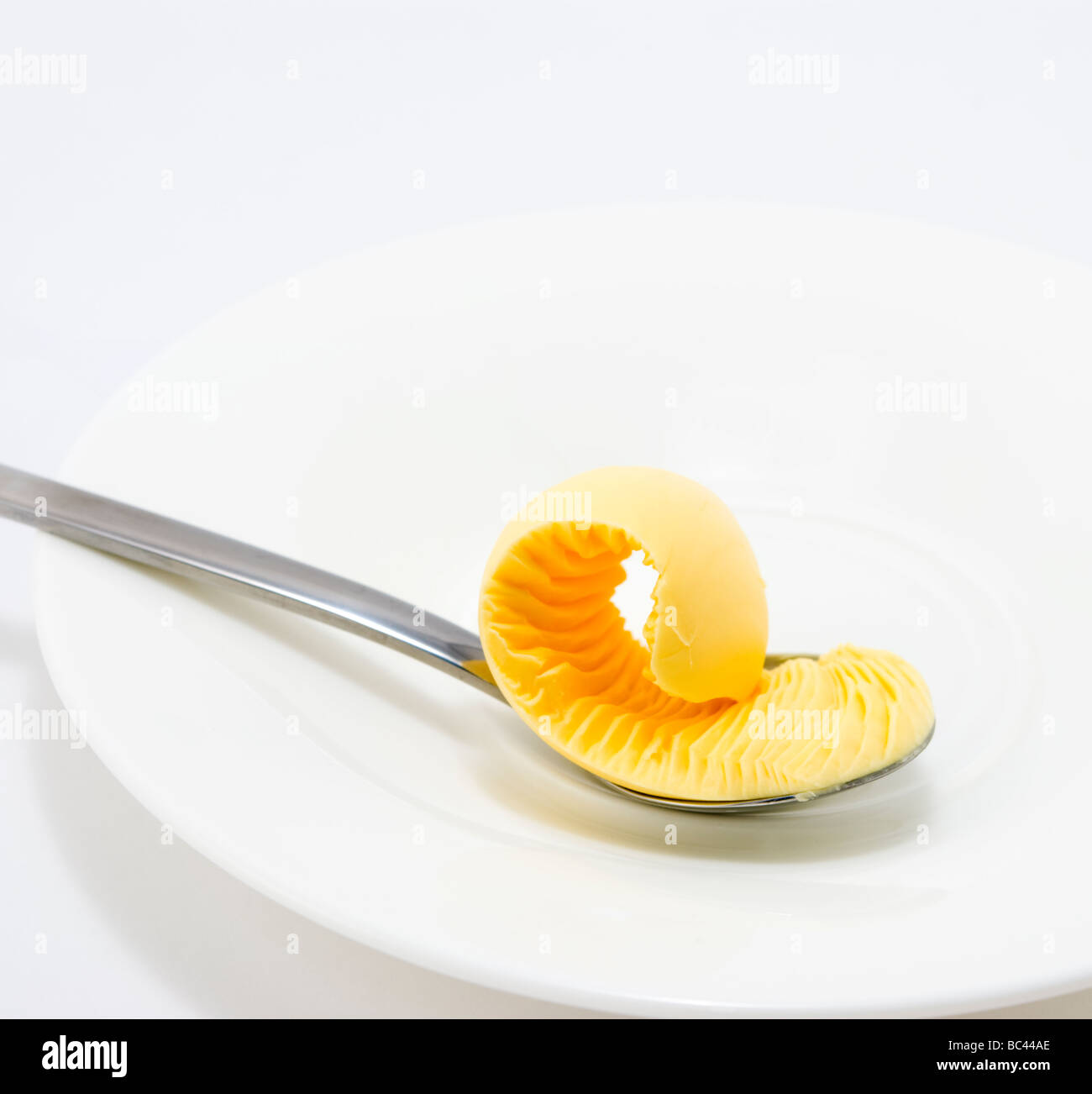 Gelato al limone su un cucchiaio d'argento e piastra bianca Foto Stock