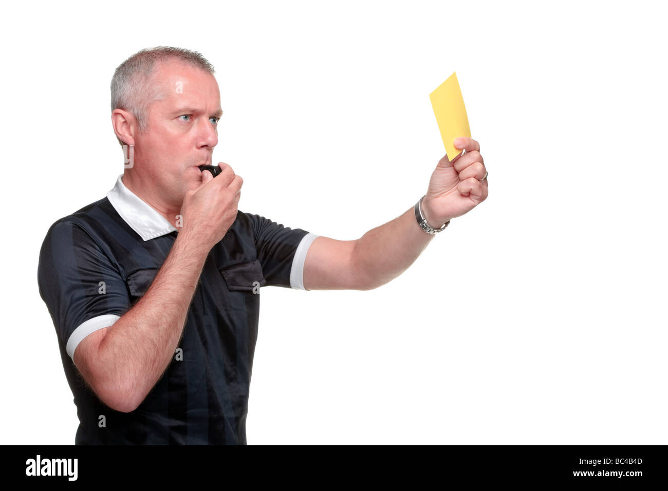 Il profilo laterale di un arbitro che mostra il cartellino giallo isolato su uno sfondo bianco Foto Stock