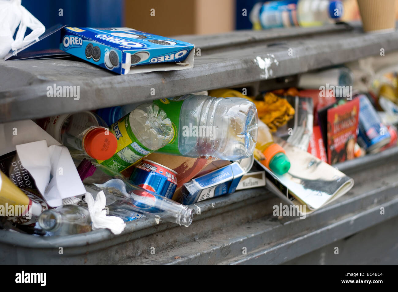 Un cestino dell'immondizia trabocca in strada. Foto Stock
