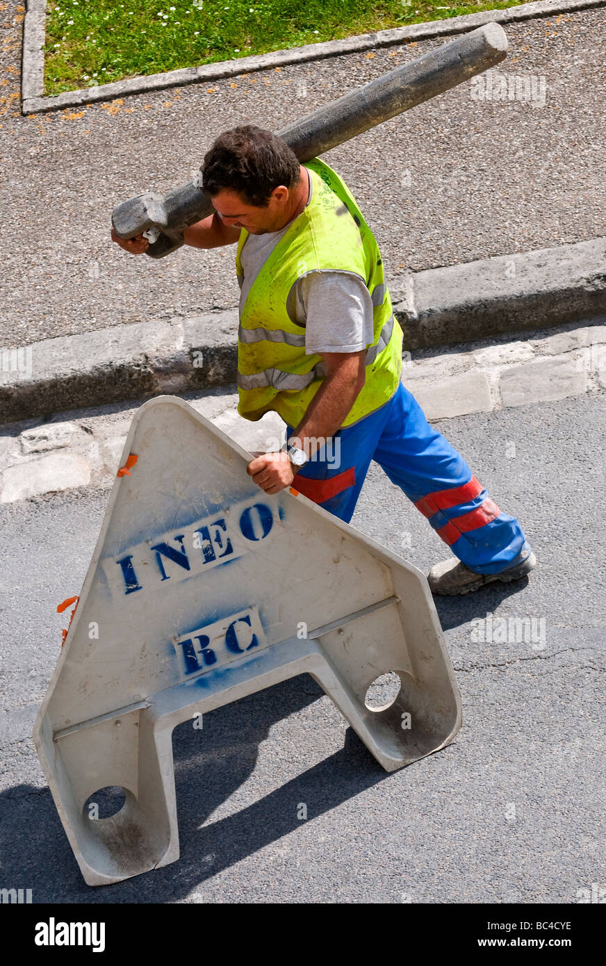 Lavori stradali contraente spingendo la sicurezza triangolo di avvertimento lungo la strada - Francia. Foto Stock