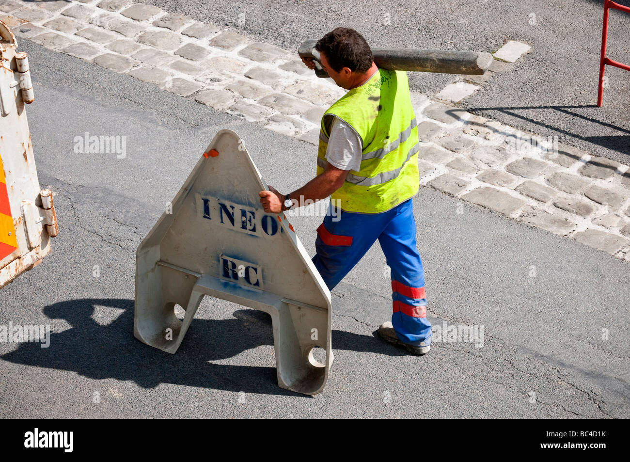 Lavori stradali contraente spingendo la sicurezza triangolo di avvertimento lungo la strada - Francia. Foto Stock