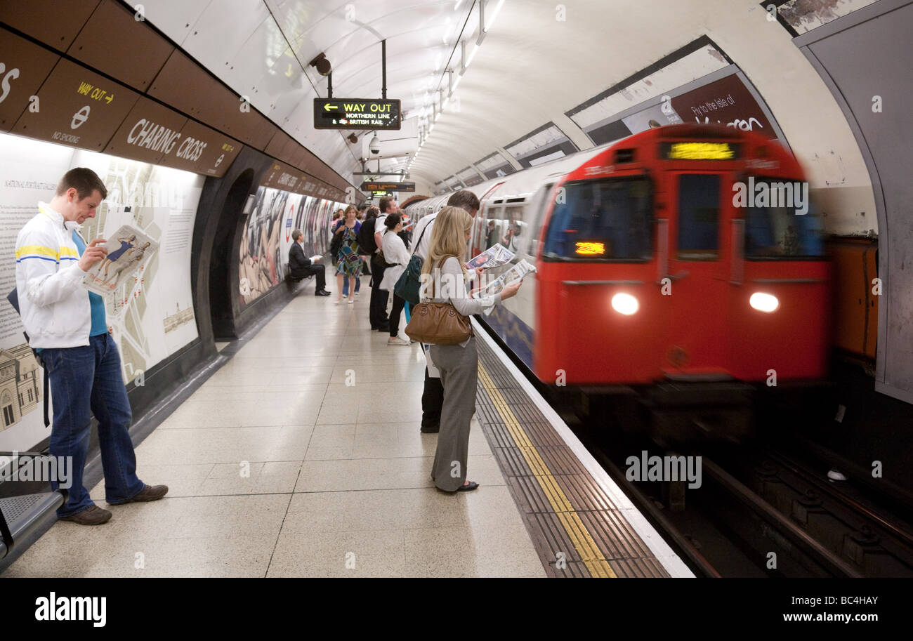 Le persone in attesa di un treno sulla piattaforma a Charing Cross, Stazione della metropolitana di Londra, Regno Unito Foto Stock