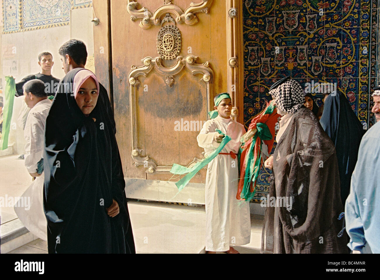 Fedeli a uno dei gateway per l'Imam moschea Husayn e santuario durante il santo periodo di Ashura, a Kerbala, Iraq. Foto Stock