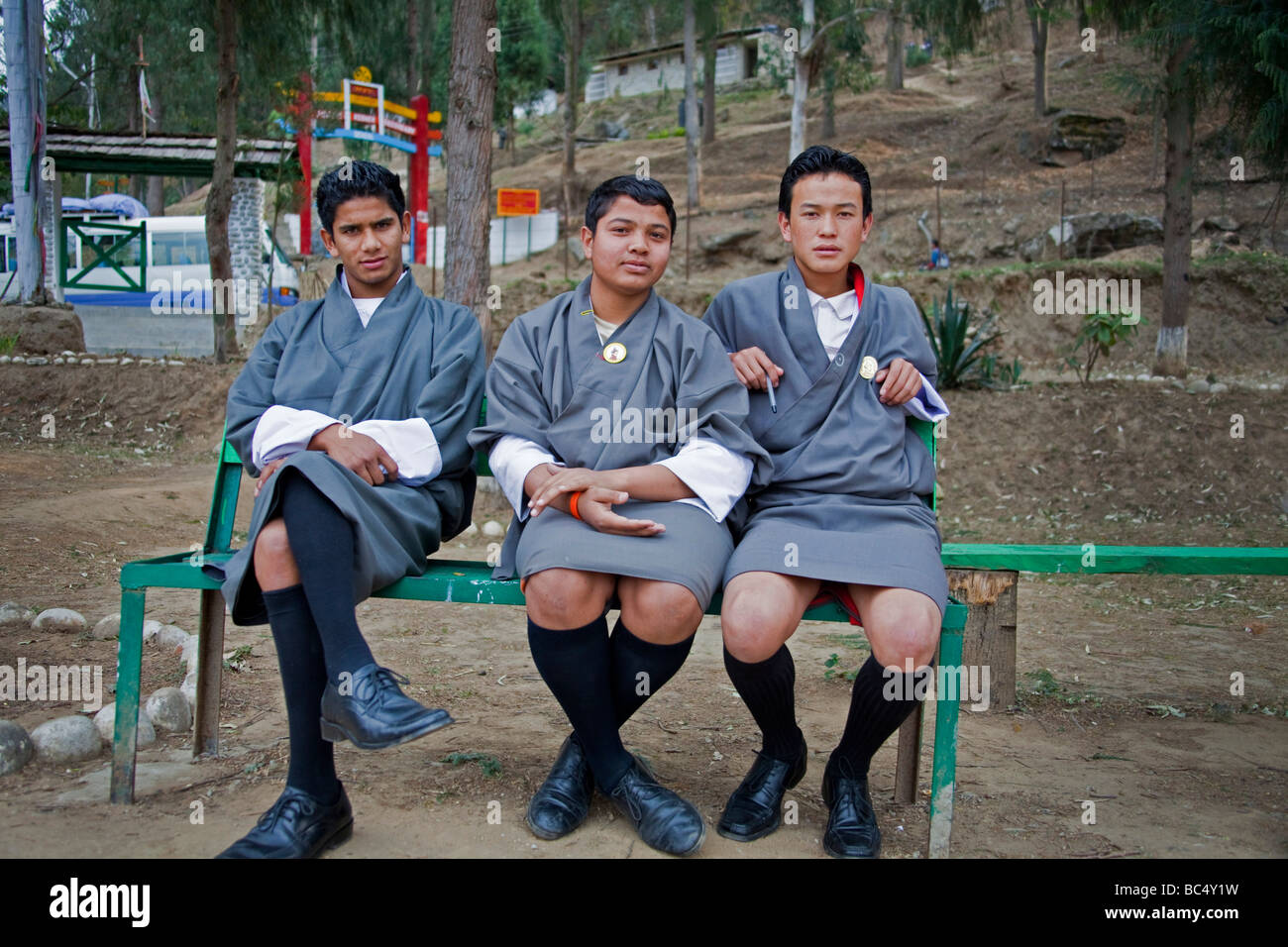 Giovane debuttante monaci gli studenti in grigio unifiorms seduta sul banco di lavoro al di fuori di Punakha Dzong monastero .91588 Orizzontale Bhutan-Punakha Foto Stock