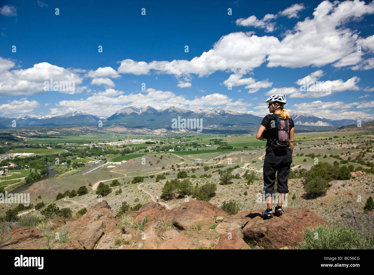 La donna si interrompe durante una montagna in bicicletta per godere la vista dell'Arkansas River Valley e Salida Colorado USA Foto Stock