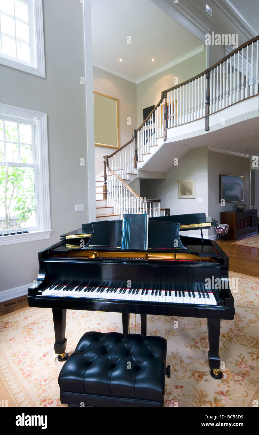 Grand piano in palazzina soggiorno con scala e grandi finestre Foto Stock