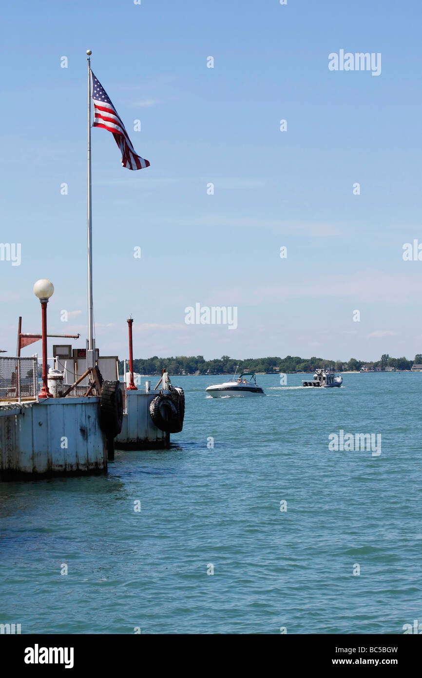 Il lago Erie si trova nel paesaggio della baia, Ohio, USA, con la bandiera degli Stati Uniti su un palo e le barche a motore all'orizzonte, scena fotografica verticale ad alta risoluzione Foto Stock