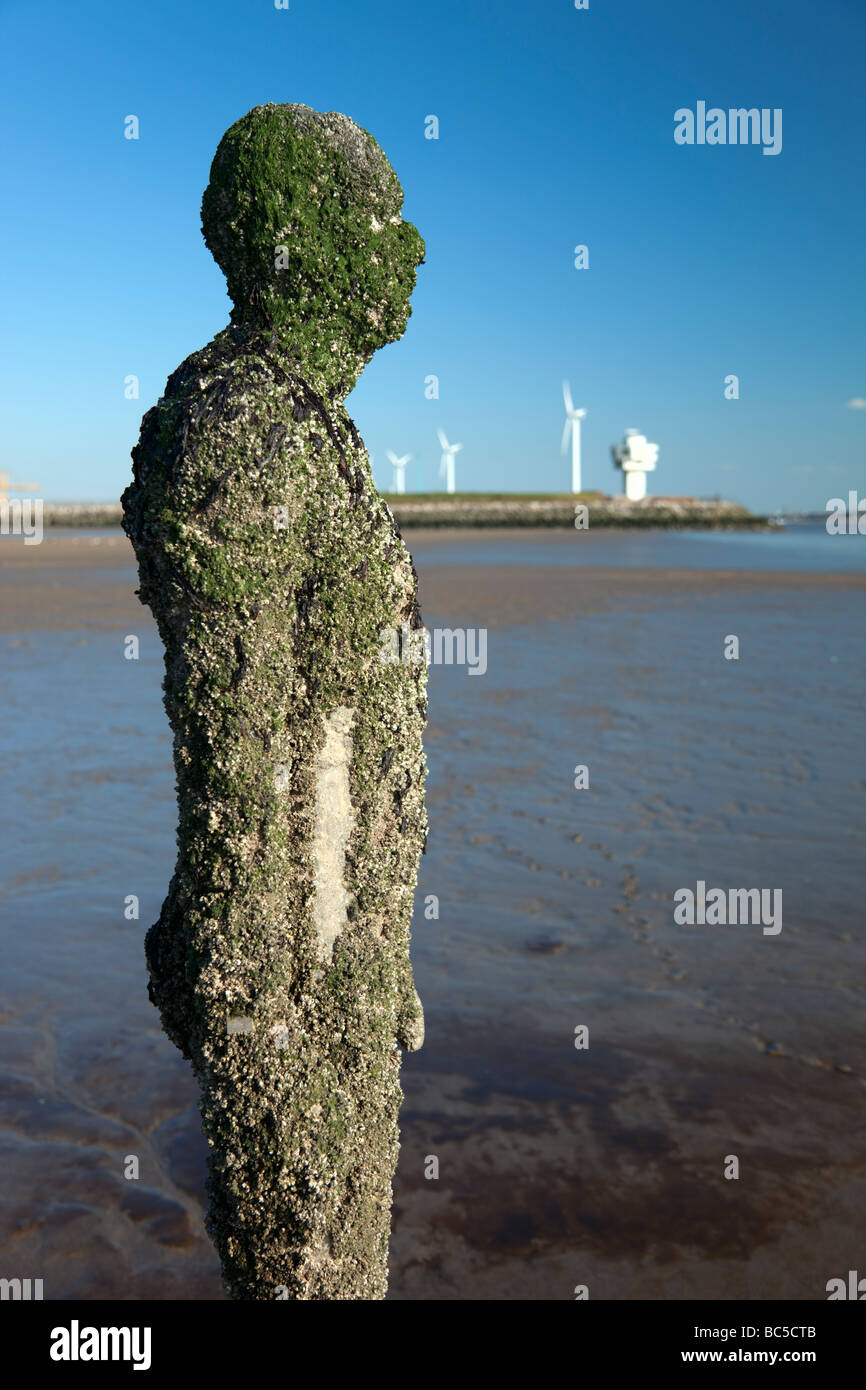 Sir Antony Gormley artwork in altro luogo si trova sulla spiaggia di Crosby che forma parte della costa di Sefton, entro il Liverpool City regione del Regno Unito. Foto Stock
