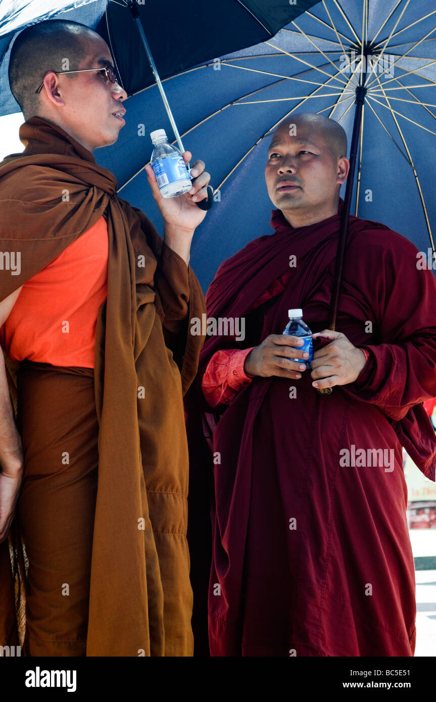 Due uomini birmani sotto gli ombrelloni a una politica dei rally per salvare la Birmania a Washington DC. Foto Stock